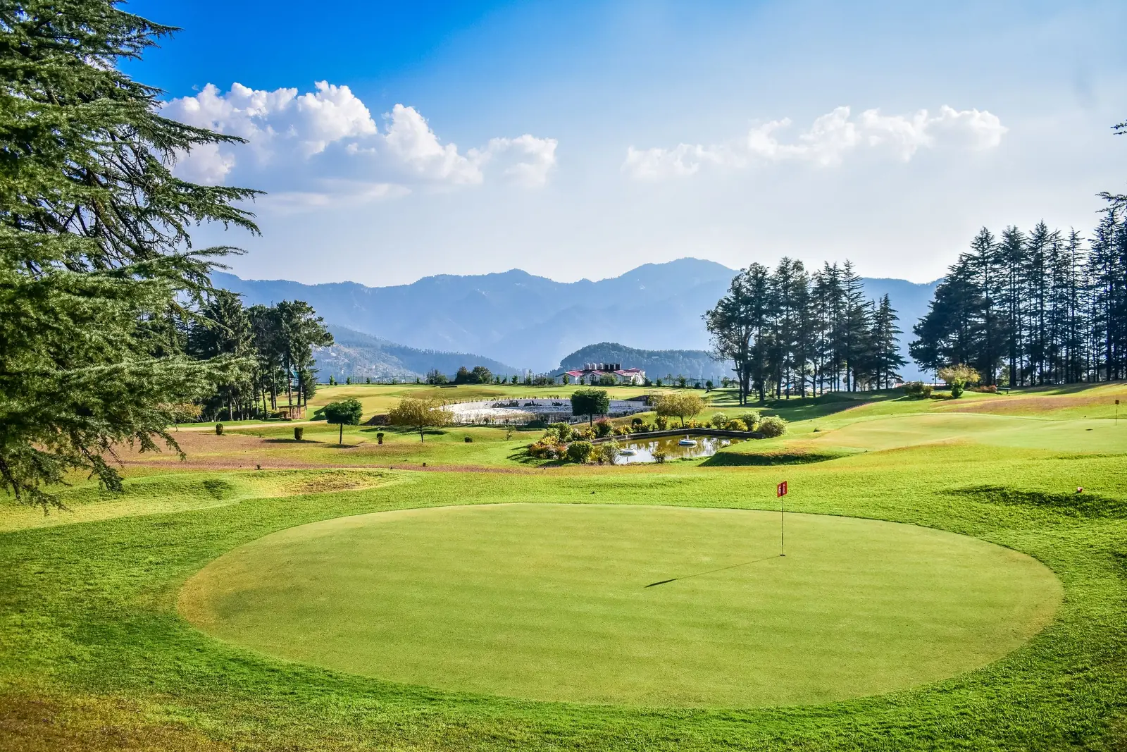 Golf green and fairway with mountains in the distance