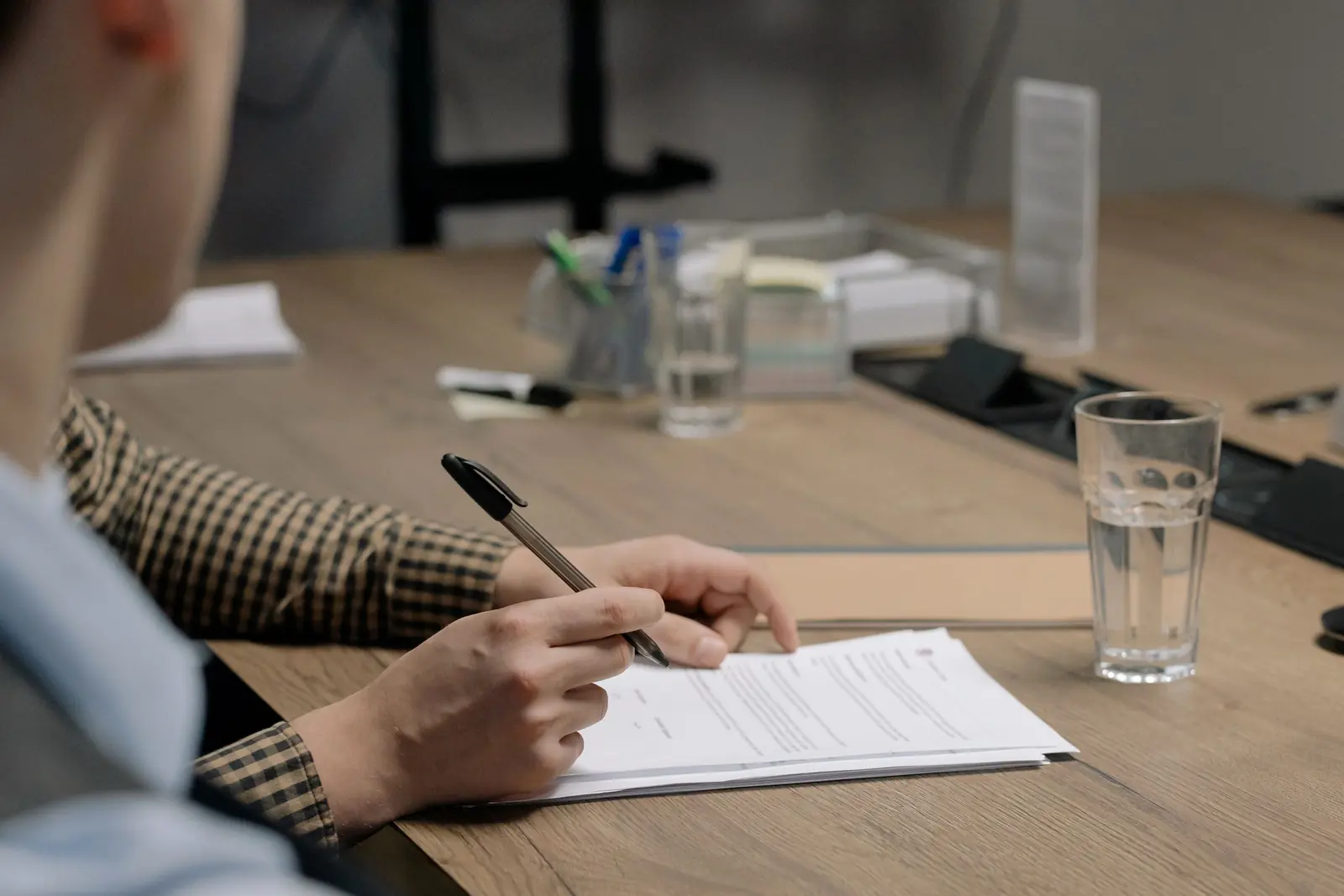 Person signing an administrative form at a desk