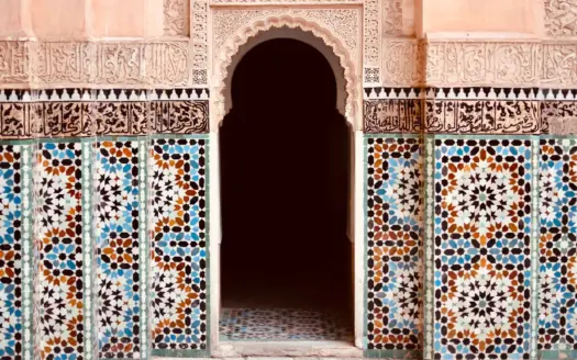 Zellige tilework and carved stucco around a pointed arch
