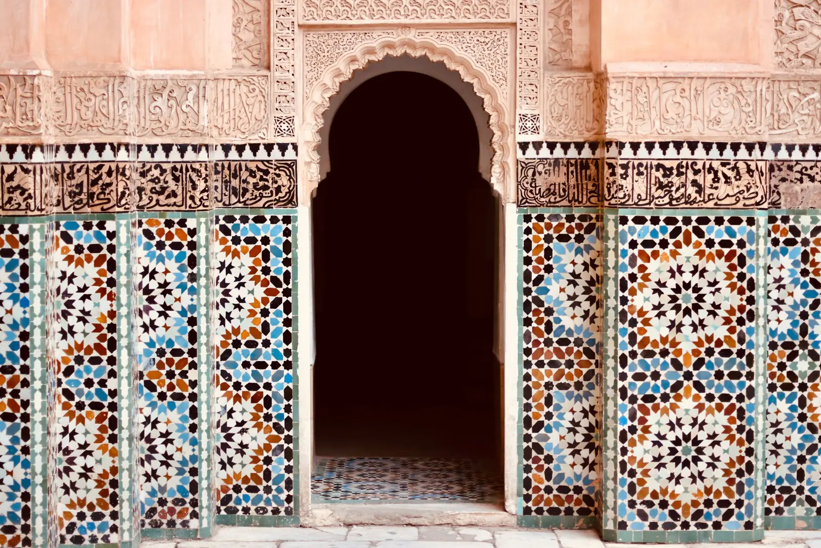 Zellige tilework and carved stucco around a pointed arch