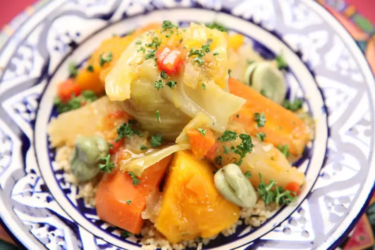 Couscous topped with vegetables on a patterned plate