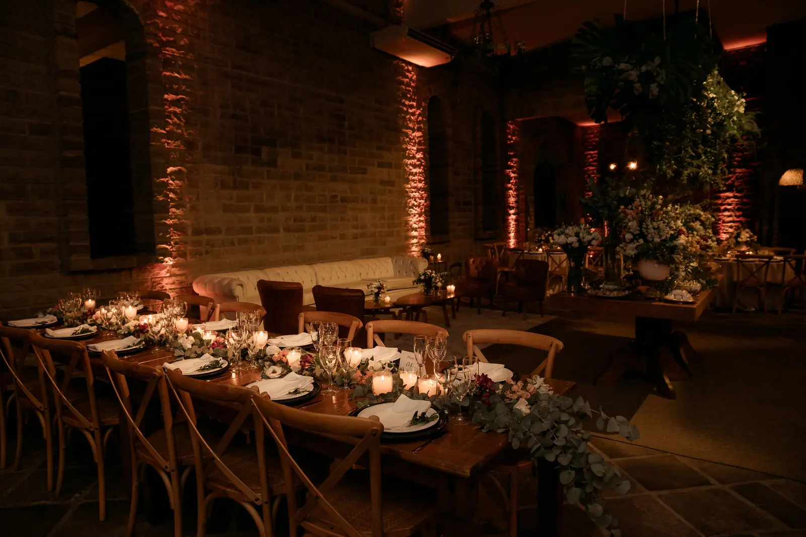 Candlelit banquet tables set for a celebration in an event hall