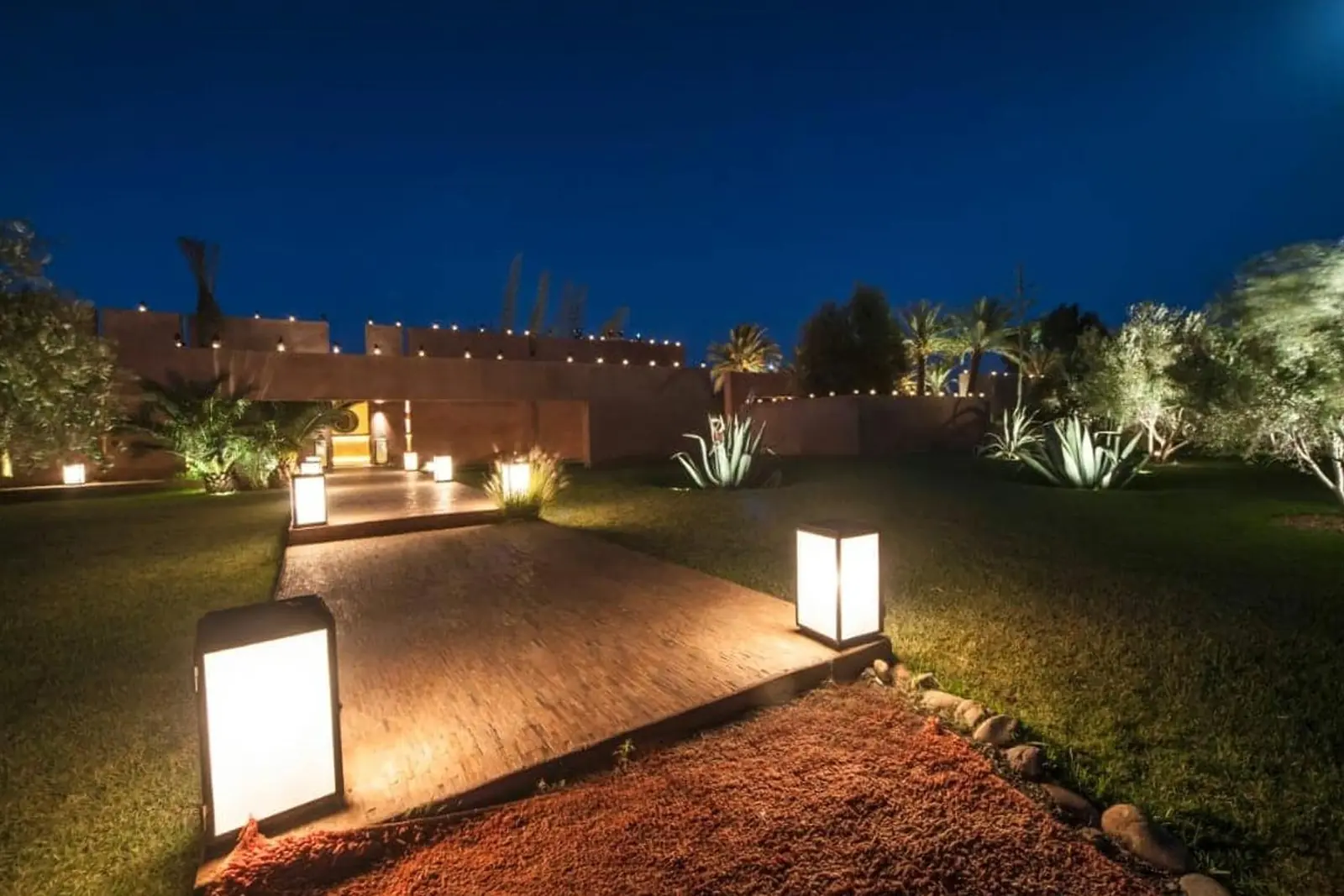 Garden path lit by lanterns at night at Olive Palace, Marrakech