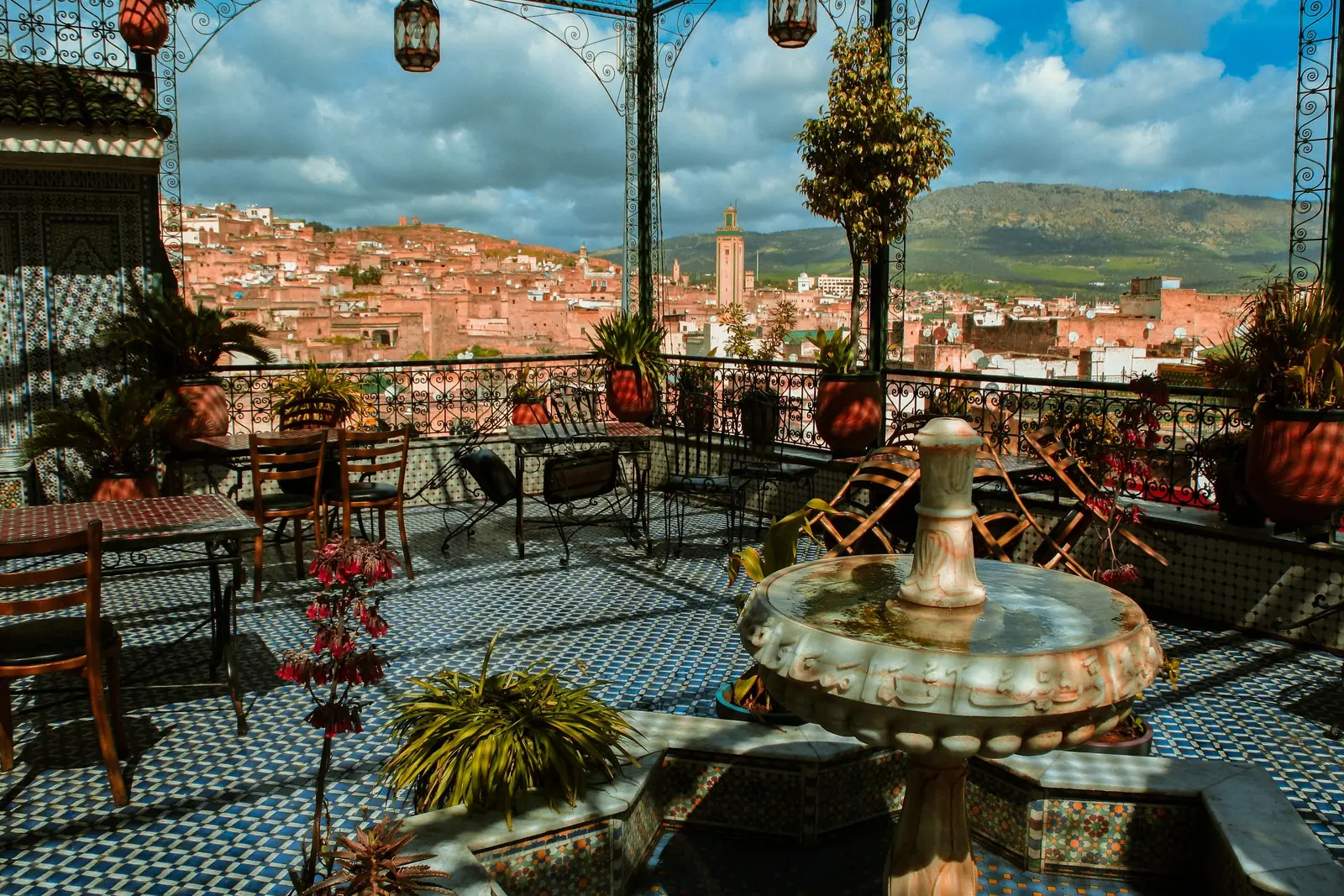 Tiled rooftop terrace with a fountain overlooking an old city