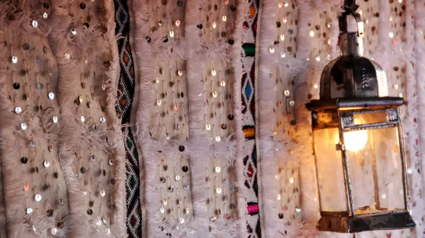Lit lantern against a studded Moroccan wall