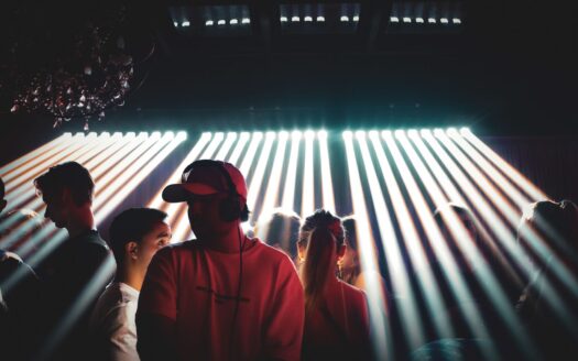 Dance floor of a Marrakech nightclub at night, DJ playing under beams of stage light