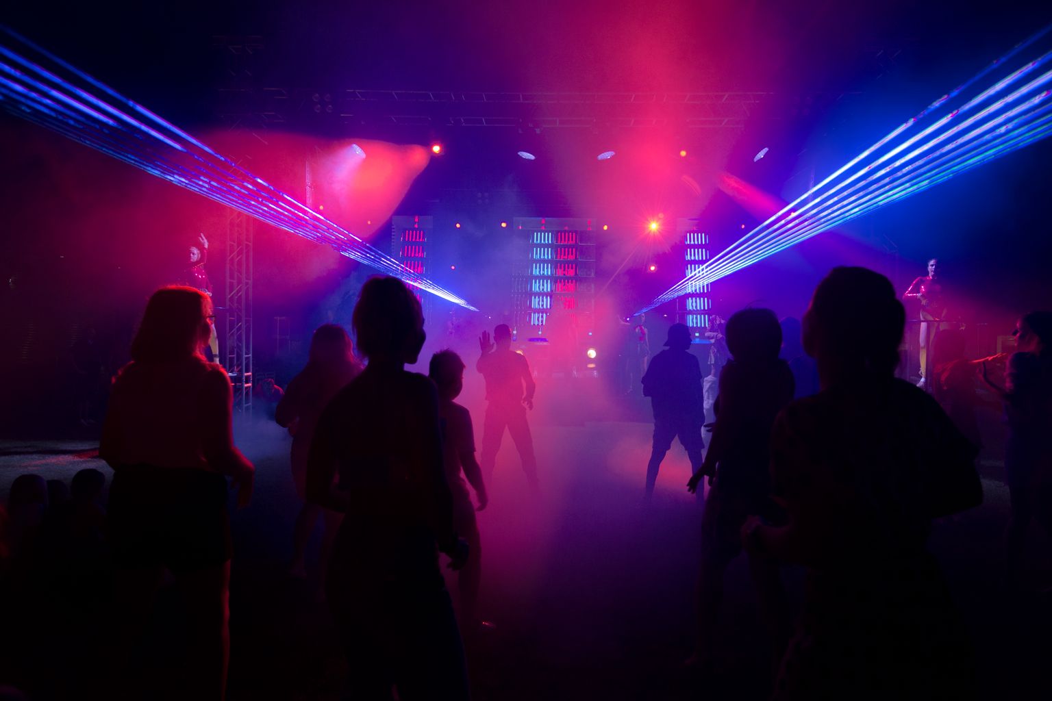 Crowd dancing under blue and red laser beams on a packed nightclub dance floor in Marrakech