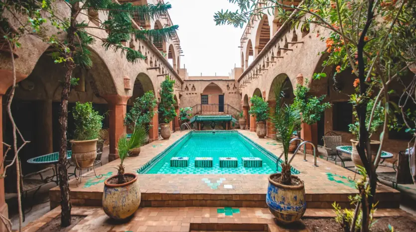 Patio d'un riad traditionnel avec bassin, plantes et arcades
