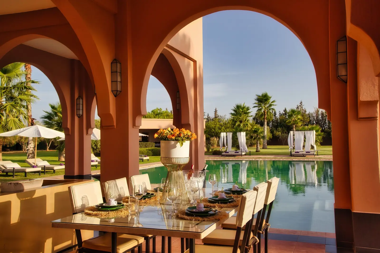 Table dressée sous les arcades, face à la piscine de la Villa Andalucía