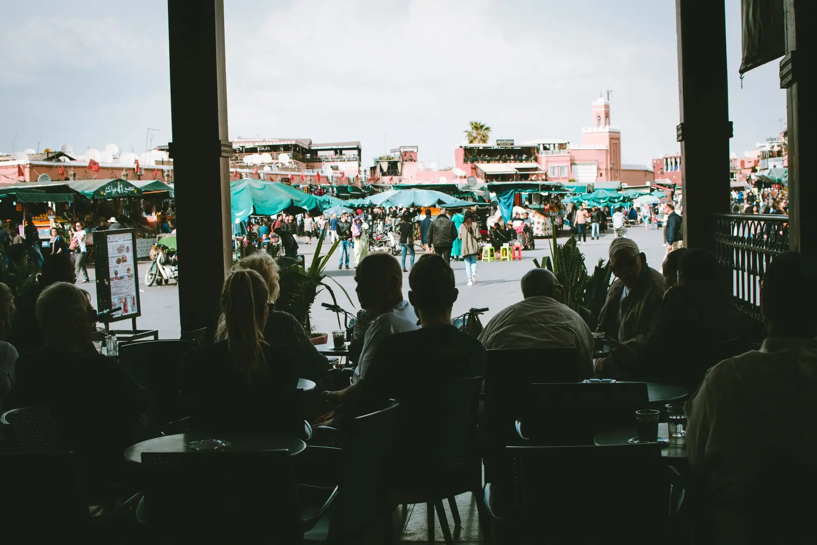 Shaded café terrace overlooking Jemaa el-Fna square and its stalls