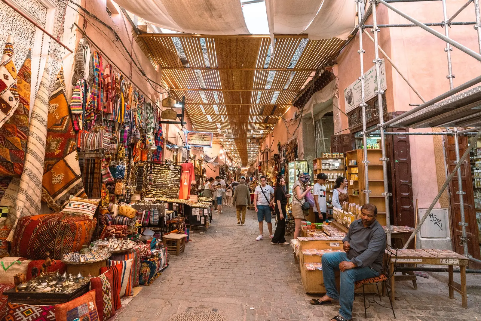 Covered souk lane lined with rugs, lamps and craft stalls