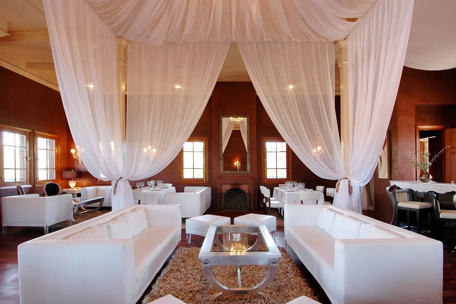 Restaurant dining room with draped fabric and white sofas