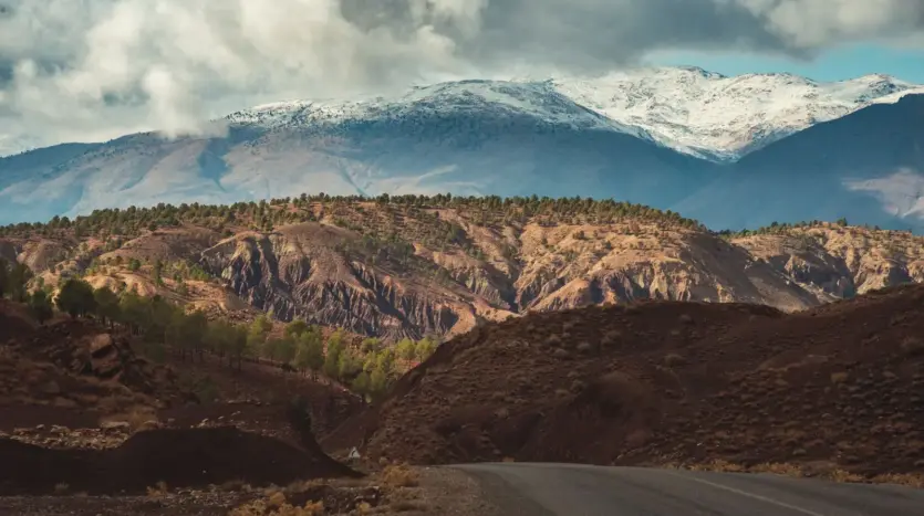 Road through the High Atlas below snow-dusted peaks