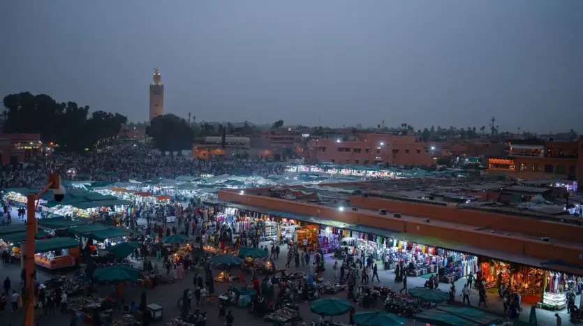 Jemaa el-Fna at dusk, with the Koutoubia minaret in the distance