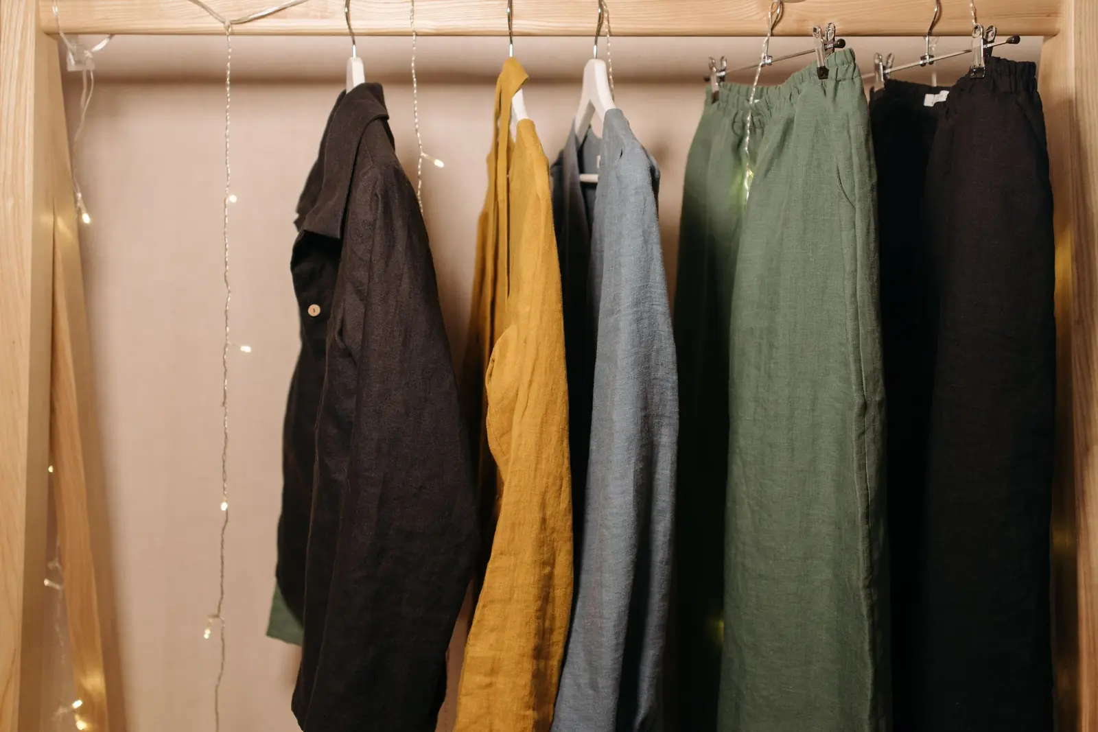 Linen shirts, jackets and trousers on hangers