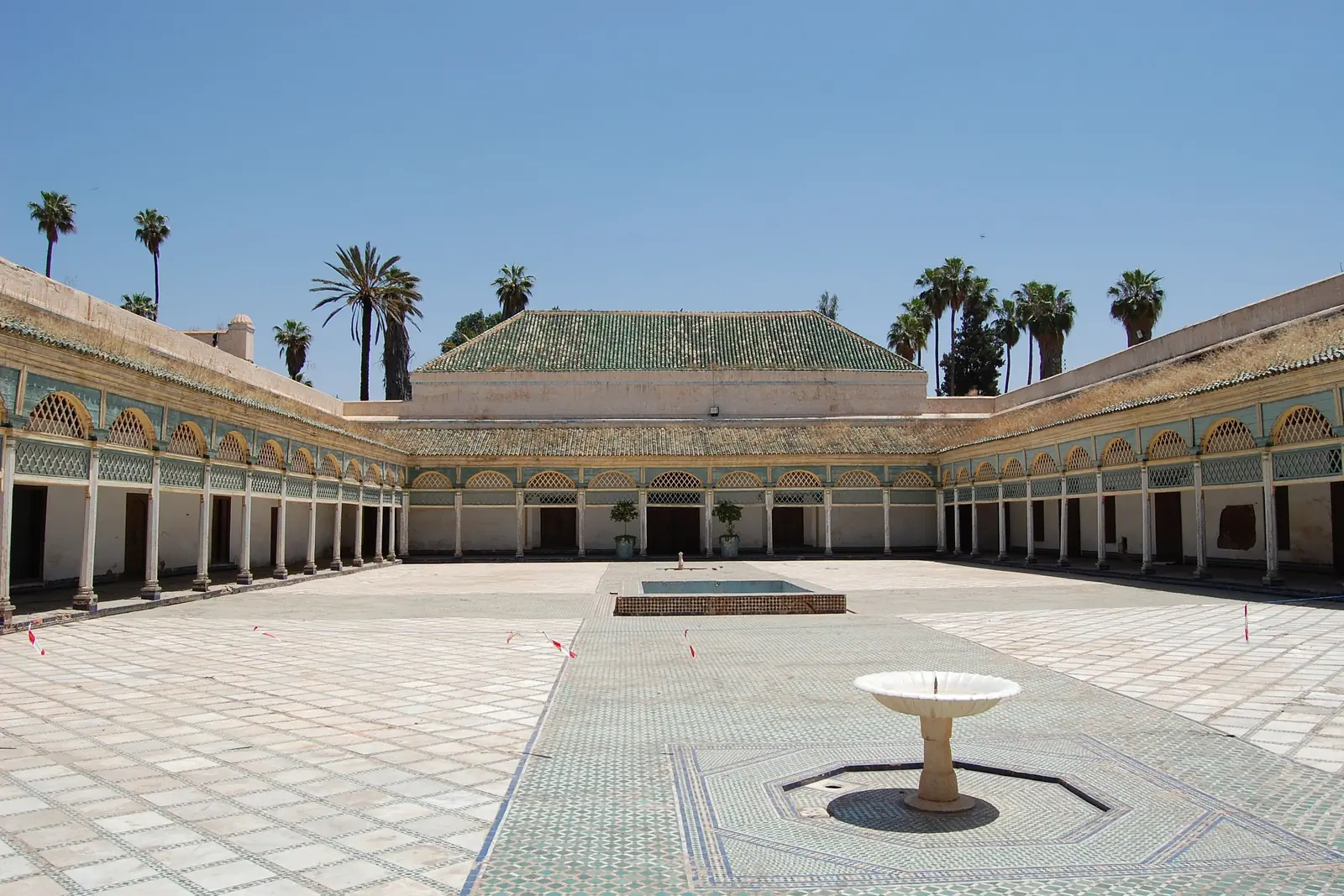 Tiled palace courtyard with a central fountain and green-roofed galleries