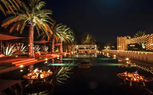 Piscine éclairée et palmiers de l'Olive Palace, la nuit