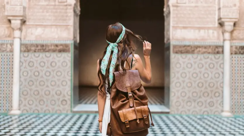 Woman traveller with a backpack in the courtyard of the Ben Youssef Medersa