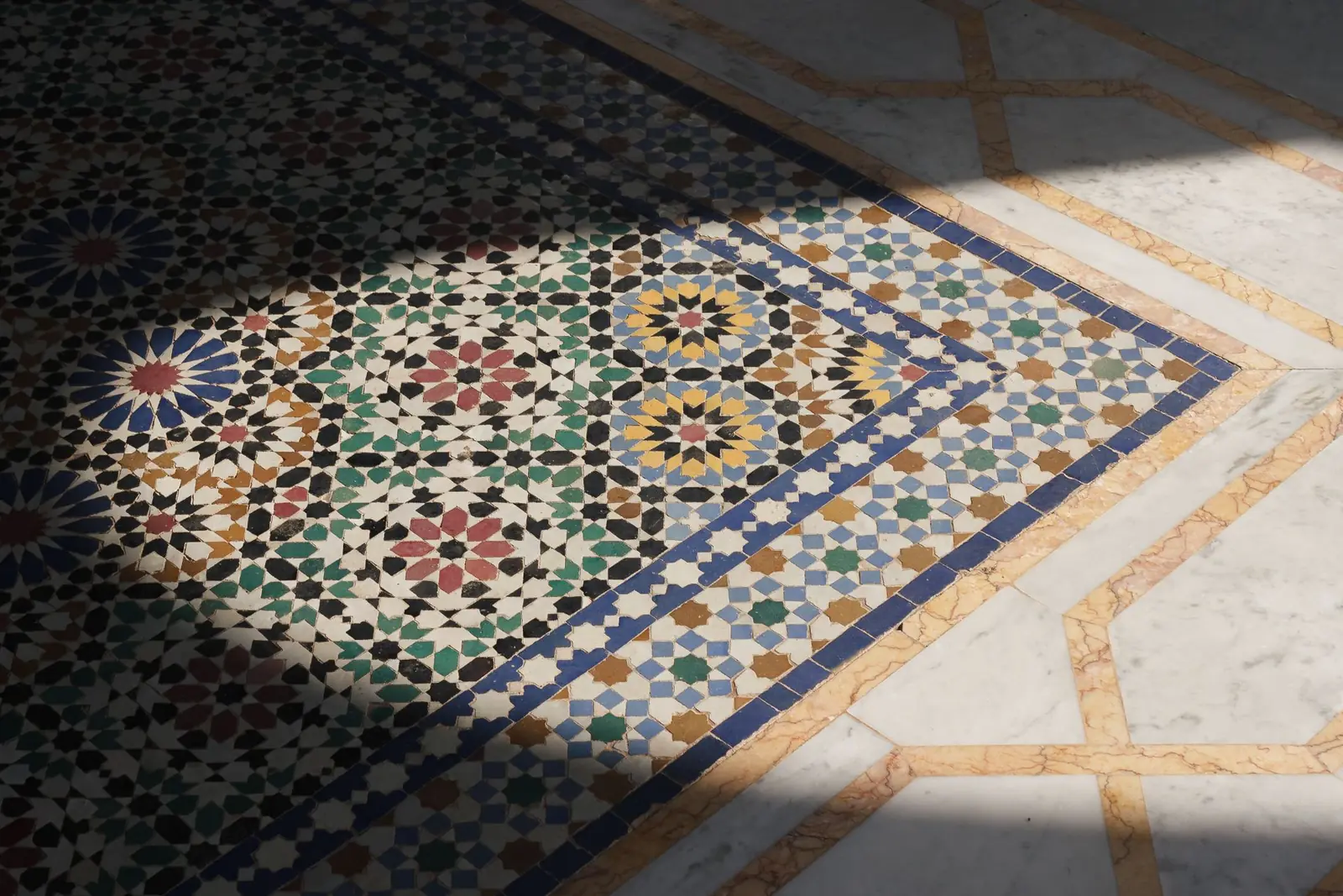 Detail of a hand-cut zellige mosaic floor in sunlight