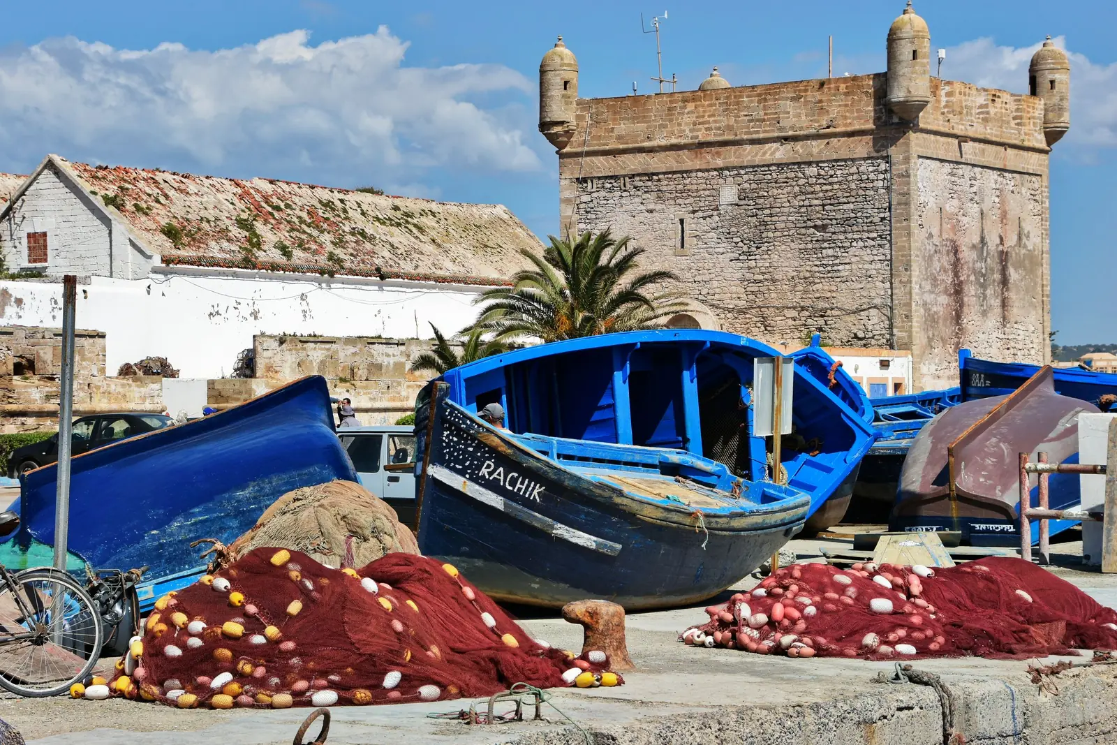 Blue fishing boats and nets below the Skala fortress at Essaouira port