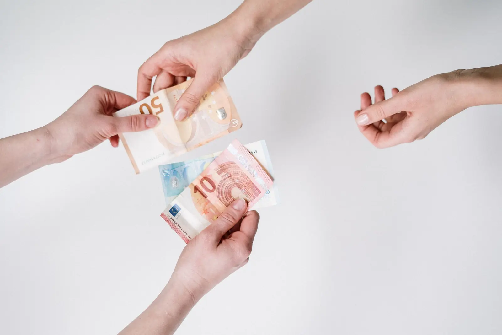Euro banknotes being handed from one person to another