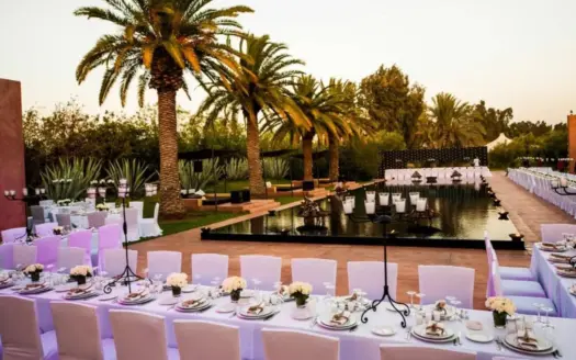 Long banquet table set beside the pool at Olive Palace at dusk