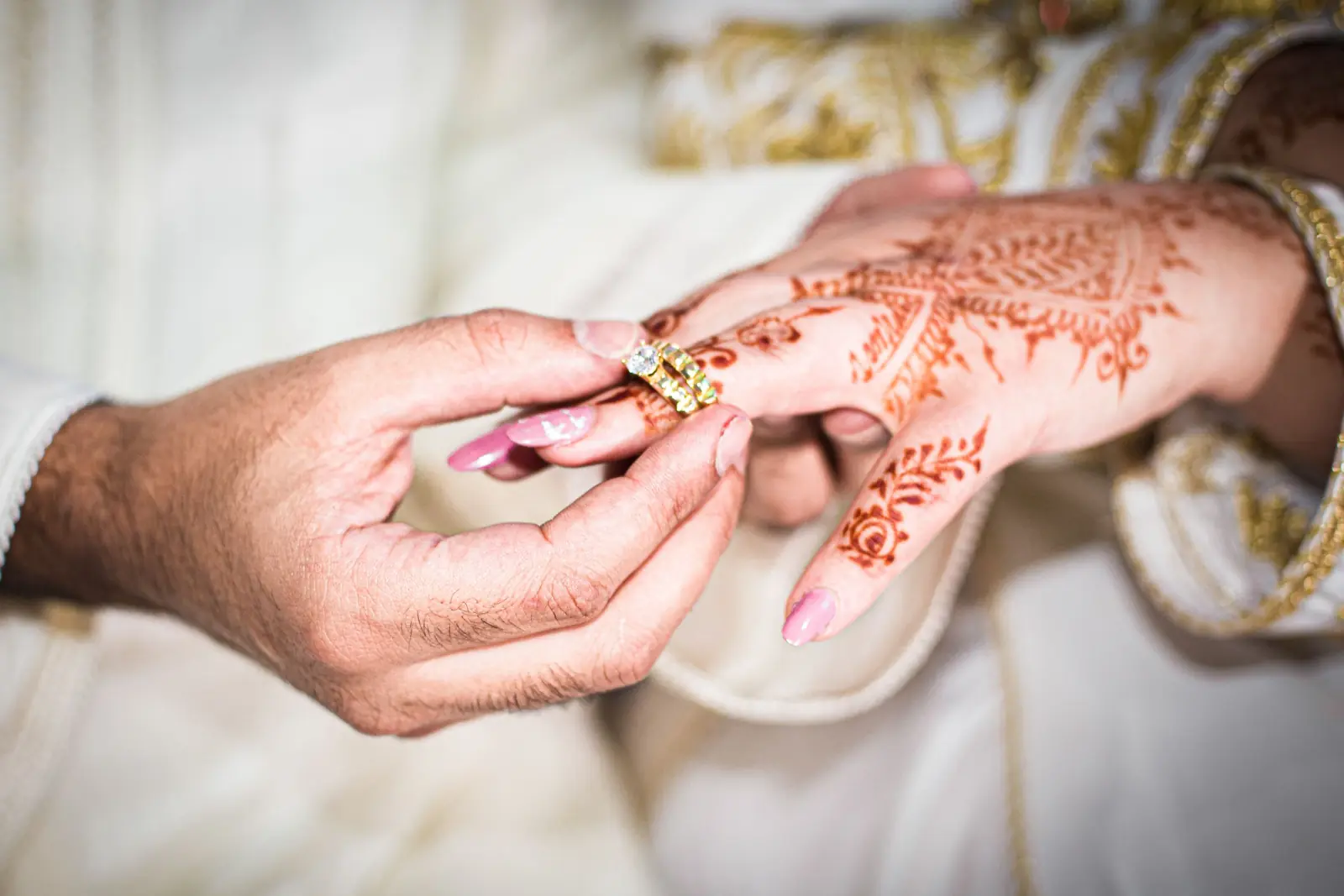 Ring being slipped onto a hand decorated with henna