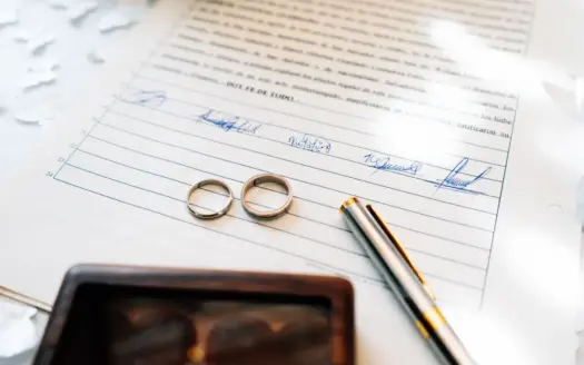 Two wedding rings resting on a signed marriage certificate