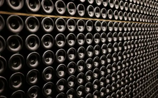 Rows of wine bottles stacked on their sides in a cellar